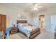 Main bedroom featuring carpet flooring, a ceiling fan, a floral painting, and a wooden bed frame at 1037 Green Gate Blvd, Groveland, FL 34736