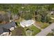 Aerial view of a home with green lawn near lake with trees, driveway, and neighboring houses at 1041 Eastbrook Ave, Deltona, FL 32738