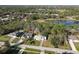 Aerial shot of a home nestled on a wooded lot with pond views and neighboring houses at 1041 Eastbrook Ave, Deltona, FL 32738