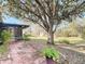 Backyard features a brick patio, large shade tree, and a view of the woods at 1041 Eastbrook Ave, Deltona, FL 32738