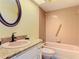 Cozy bathroom features a rounded mirror, combo tub and shower with grab bar at 1041 Eastbrook Ave, Deltona, FL 32738