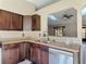 Traditional-style kitchen featuring dark wood cabinets, granite countertops and stainless-steel dishwasher at 1041 Eastbrook Ave, Deltona, FL 32738