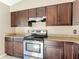 Well-equipped kitchen featuring stainless steel appliances, granite countertops, and dark wood cabinets at 1041 Eastbrook Ave, Deltona, FL 32738