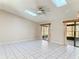 Open-concept living room with tile floors, neutral walls, ceiling fans, and sliding glass doors at 1041 Eastbrook Ave, Deltona, FL 32738