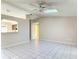 Bright living room featuring neutral walls, tile flooring, ceiling fan, and a pass-through to the kitchen at 1041 Eastbrook Ave, Deltona, FL 32738