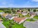 Aerial view of a residential community featuring well-maintained homes, green lawns, and mature trees at 1106 Blythe Way, The Villages, FL 32162