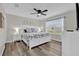 Bedroom with a king-size bed, ceiling fan, and natural light from a large window at 1106 Blythe Way, The Villages, FL 32162