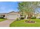 Charming home with a well-manicured lawn and a beautiful tree in the front yard at 1106 Blythe Way, The Villages, FL 32162