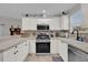 A stylish kitchen with stainless steel appliances, light countertops, and modern fixtures at 1106 Blythe Way, The Villages, FL 32162