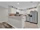 Bright kitchen with stainless steel appliances, light countertops, breakfast bar, and mixed flooring at 1106 Blythe Way, The Villages, FL 32162