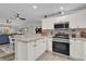 Open-concept kitchen featuring a breakfast bar, stainless steel appliances, and neutral color palette at 1106 Blythe Way, The Villages, FL 32162