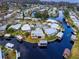 Aerial view of a waterfront Florida community with mature landscaping and single-story homes along a canal at 1112 Forest Ln, Tavares, FL 32778