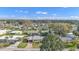 Wide aerial view of a Florida community with mature landscaping, single-story homes, and clear blue sky at 1112 Forest Ln, Tavares, FL 32778