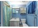 Bathroom featuring blue walls, a vanity, toilet, and shower with a patterned curtain at 1112 Forest Ln, Tavares, FL 32778