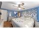 Cozy bedroom featuring a ceiling fan, blue walls, and blue and white floral accents at 1112 Forest Ln, Tavares, FL 32778