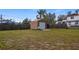 Backyard featuring a shed with roll up door, providing ample storage space at 119 E Croton Way, Howey In The Hills, FL 34737