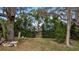 Landscaped backyard with mature trees and a tranquil garden gate at 119 E Croton Way, Howey In The Hills, FL 34737