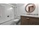 Well-lit bathroom with a shower over the tub and a stylish oval mirror above a modern vanity at 119 E Croton Way, Howey In The Hills, FL 34737