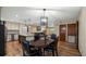 Open-concept dining area featuring hardwood floors, a modern light fixture, and seamless flow to the kitchen at 119 E Croton Way, Howey In The Hills, FL 34737