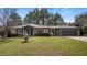 Charming single-story brick home featuring a well-manicured lawn and a classic water fountain at 119 E Croton Way, Howey In The Hills, FL 34737