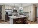 Well-lit kitchen featuring stainless steel appliances, stylish counters, tiled backsplash, and a central island with seating at 119 E Croton Way, Howey In The Hills, FL 34737