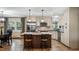 Bright kitchen with stainless steel refrigerator and microwave, pendant lighting and island with barstool seating at 119 E Croton Way, Howey In The Hills, FL 34737