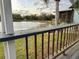 Lake view from a backyard deck, complemented by a well-manicured lawn and mature trees at 12066 Se 60Th Avenue Rd, Belleview, FL 34420