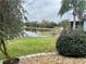 A home's lawn features a pond and a lush palm tree in the backyard at 12066 Se 60Th Avenue Rd, Belleview, FL 34420