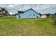 Expansive backyard with lush green grass, a light blue house and white gravel at 12066 Se 60Th Avenue Rd, Belleview, FL 34420