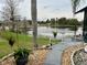 Backyard view with a view of the lake, hanging plants, stone landscaping, and manicured trees at 12066 Se 60Th Avenue Rd, Belleview, FL 34420