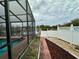 View of a backyard, including pool with enclosure, and partial view of a lake at 12066 Se 60Th Avenue Rd, Belleview, FL 34420