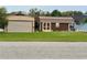 Exterior view featuring a tan metal garage with a rolling door and a small brown shed at 12066 Se 60Th Avenue Rd, Belleview, FL 34420