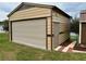 Detached metal garage has a rolling door on the front and a side entry door. There is ample lawn space around the garage at 12066 Se 60Th Avenue Rd, Belleview, FL 34420