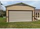 Garage with a brown trim and a large, horizontal rolling door, providing extra storage or workspace at 12066 Se 60Th Avenue Rd, Belleview, FL 34420