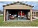 Open garage interior with a trailer and wheelbarrow, offering lots of space for storage of equipment and vehicles at 12066 Se 60Th Avenue Rd, Belleview, FL 34420