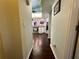 Hallway with hardwood floors that leads to the open kitchen with white cabinets and stainless steel appliances at 12066 Se 60Th Avenue Rd, Belleview, FL 34420