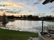 Overlooking a scenic pond, this home features a serene landscape at sunset at 12066 Se 60Th Avenue Rd, Belleview, FL 34420