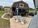 An exterior view of the shed with an umbrella table, showcasing outdoor living space with a view of the water at 12066 Se 60Th Avenue Rd, Belleview, FL 34420