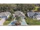 Aerial view of the home with palm trees, driveway and garage, and the home's proximity to mature trees at 1209 Barcelona Dr, The Villages, FL 32159