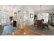 Open-concept dining room with hardwood floors, a chandelier, and a view of the kitchen at 1209 Barcelona Dr, The Villages, FL 32159