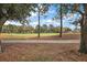 The golf course view features mature trees, green grass, and paved sidewalk perfect for a morning stroll at 1209 Barcelona Dr, The Villages, FL 32159