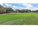 View of the golf course on a sunny day, featuring a sand trap with a manicured green lawn and mature trees at 1209 Barcelona Dr, The Villages, FL 32159