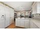 Open kitchen with white cabinets, countertops, and stainless steel refrigerator, connecting to dining area at 1209 Barcelona Dr, The Villages, FL 32159