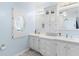 Bright bathroom features a double vanity, cabinets, and a large mirror at 12221 Helena Ct, Leesburg, FL 34788