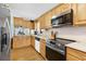 View of the kitchen with modern appliances, countertop, and wooden cabinets at 12221 Helena Ct, Leesburg, FL 34788