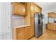 Bright kitchen features wooden cabinets, wine rack, and stainless steel refrigerator at 12221 Helena Ct, Leesburg, FL 34788