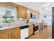 Bright kitchen with a window, stainless steel appliances, and an adjacent laundry area at 12221 Helena Ct, Leesburg, FL 34788