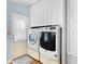 Modern laundry room features a washer and dryer set and cabinets at 12221 Helena Ct, Leesburg, FL 34788