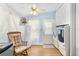 Laundry room includes a ceiling fan, window, washer and dryer, and cushioned rocking chair at 12221 Helena Ct, Leesburg, FL 34788