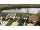 Aerial view of homes with manicured lawns by a serene lake, some featuring solar panels at 123 Dresdan Ct, Sanford, FL 32771